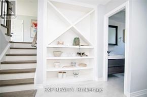 Oakville (Wo West) apartment for rent - A white shelving unit with various decorative items is in a room with a staircase.