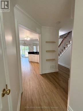Oakville (Wt West Oak Trails) townhouse for rent - A hallway with a wooden floor and a staircase with white railings.