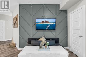 Milton (Wi Willmott) condo for rent - A modern bedroom with a large bed and a painting on the wall.