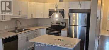 Kingston (City Northwest) townhouse for rent - A kitchen with a refrigerator, stove, and sink.