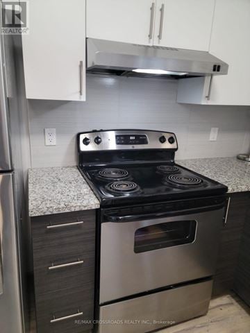 Waterloo condo for rent - A stainless steel oven with a black top is in a kitchen.