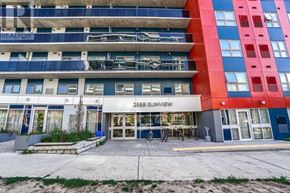 Waterloo condo for rent - The image shows a multi-story building with a blue and red facade and a sign that reads "2355 Sunview".