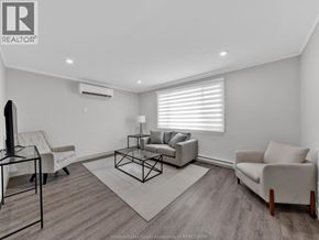 Windsor apartment for rent - A living room with a white couch, a black chair, and a glass table.