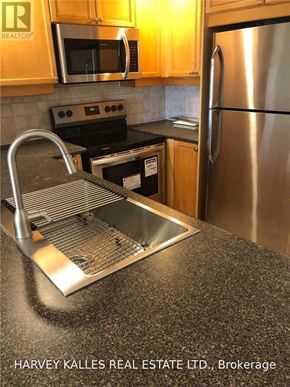 Toronto (Willowdale East) condo for rent - A kitchen with a stainless steel refrigerator and a stove top oven.