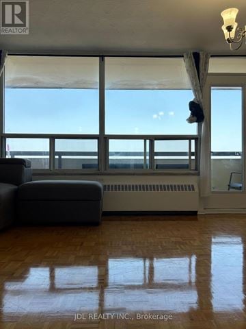 Toronto (Bayview Woods-Steeles) condo for rent - A living room with a couch and a large window overlooking the ocean.