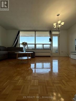 Toronto (Bayview Woods-Steeles) condo for rent - A living room with a couch, a coffee table, and a chandelier.