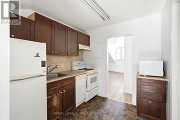 London East (East F) multi-family for rent - A kitchen with brown cabinets and white appliances.