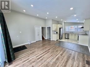 Toronto (Woburn) apartment for rent - A spacious living room with hardwood flooring and a kitchen area in the background.