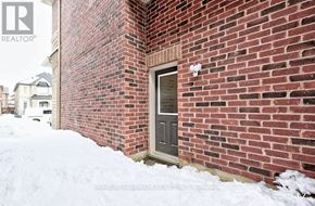 Vaughan (Kleinburg) apartment for rent - A red brick house with a grey door and snow on the ground.