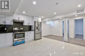 Vaughan (Kleinburg) apartment for rent - A modern kitchen with white cabinets and a blue accent on the island.