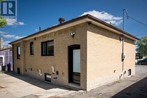 Toronto (Downsview-Roding-Cfb) apartment for rent - A small, beige building with a black door and windows.