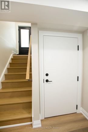 Toronto (Downsview-Roding-Cfb) apartment for rent - A white door with a black handle is in a room with a staircase.