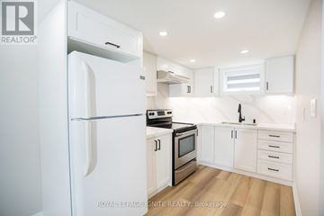 Toronto (Downsview-Roding-Cfb) apartment for rent - A white refrigerator is in a kitchen with white cabinets and stainless steel appliances.