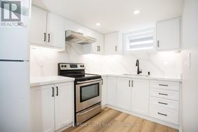 Toronto (Downsview-Roding-Cfb) apartment for rent - A white kitchen with a stove, oven, and sink.