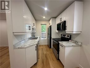 Garson apartment for rent - A kitchen with white cabinets and a marble countertop.