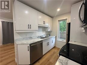 Garson apartment for rent - A kitchen with white cabinets and a black stove top.