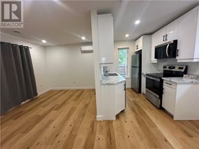 Garson apartment for rent - A kitchen with white cabinets and wooden floors.