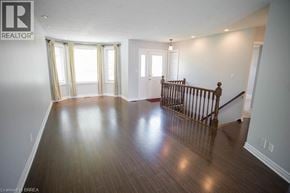 Port Dover apartment for rent - A spacious room with wooden floors and a staircase.