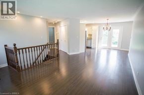 Port Dover apartment for rent - A large empty room with wood flooring and a chandelier.