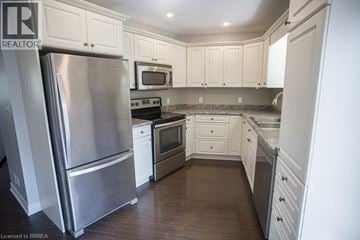 Port Dover apartment for rent - A kitchen with a stainless steel refrigerator and white cabinets.