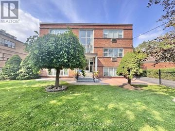 Mississauga (Cooksville) condo for rent - A well-maintained lawn in front of a brick apartment building.