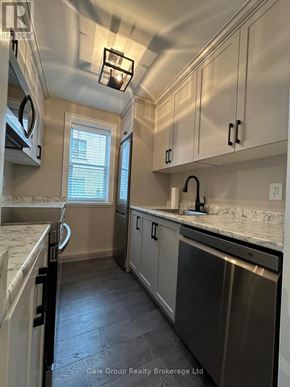 Mississauga (Cooksville) condo for rent - A kitchen with stainless steel appliances and white cabinets.