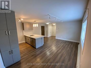 Mississauga (Cooksville) condo for rent - A spacious room with wooden flooring and a kitchenette area.