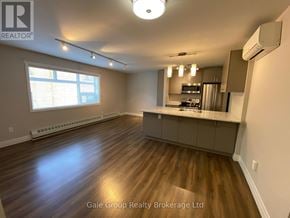 Mississauga (Cooksville) condo for rent - A spacious kitchen and living room with hardwood floors and a large window.
