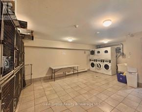 Mississauga (Cooksville) condo for rent - A laundry room with a washer and dryer, a table, and a wall-mounted shelf.