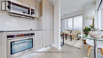 Toronto (Church-Yonge Corridor) condo for rent - A modern kitchen with a glass table and chairs in the living room.
