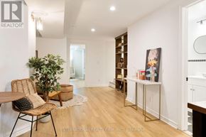 Toronto (Palmerston-Little Italy) apartment for rent - A room with a wooden floor and white walls, furnished with a chair, a table, and a potted plant.