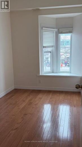 Toronto (Kensington-Chinatown) townhouse for rent - A room with a window and wooden flooring.