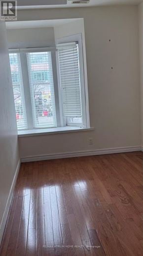 Toronto (Kensington-Chinatown) townhouse for rent - A room with wooden flooring and a window with blinds.