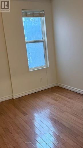 Toronto (Kensington-Chinatown) townhouse for rent - A room with a window and wooden flooring.