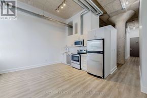 Toronto (Niagara) condo for rent - A kitchen with white appliances and wooden floors.