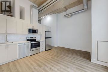 Toronto (Niagara) condo for rent - A kitchen with white cabinets and stainless steel appliances.