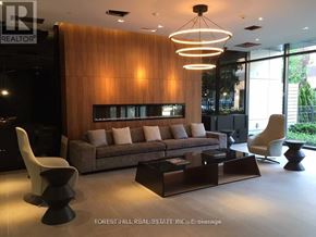 Toronto (Kensington-Chinatown) condo for rent - A modern living room with a brown couch and a wooden wall.