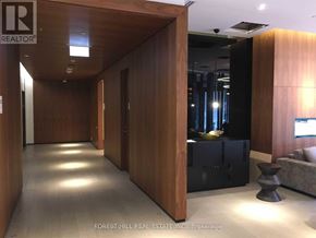 Toronto (Kensington-Chinatown) condo for rent - A hallway with wood paneling and a black sofa.