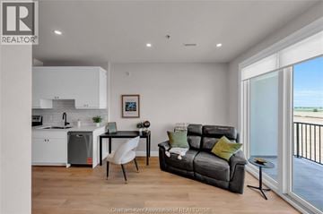 Blenheim apartment for rent - A modern living room with a grey sofa and a dining table with chairs.