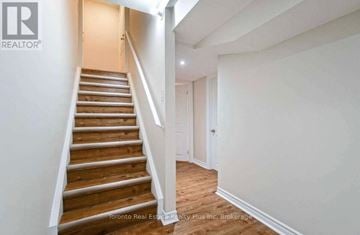 Brampton (Bram East) apartment for rent - A staircase in a house with a brokerage logo on the wall.