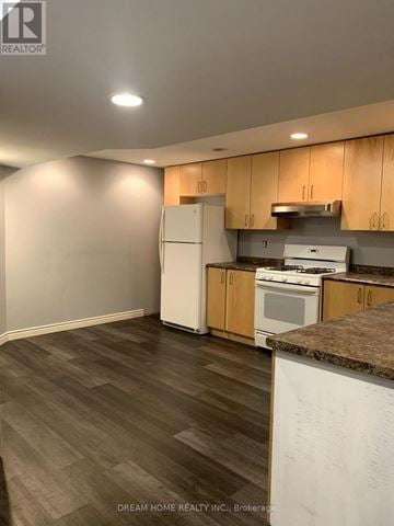 Markham (Rouge Fairways) apartment for rent - A kitchen with wooden cabinets and a white fridge.