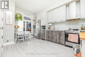 Toronto (Trinity-Bellwoods) apartment for rent - A kitchen with white cabinets and a wooden floor.