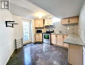 Brampton (Sandringham-Wellington) townhouse for rent - A kitchen with wooden cabinets and a granite countertop.
