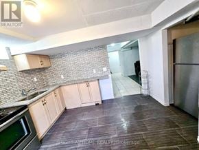 Brampton (Sandringham-Wellington) townhouse for rent - A kitchen with a stove top oven and a refrigerator.