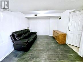 Brampton (Sandringham-Wellington) townhouse for rent - A black leather sofa sits in a white room with a wooden bench.