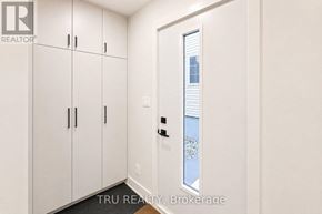 Ottawa apartment for rent - A white door with a window in the middle of a white wall.
