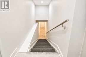 Ottawa apartment for rent - A staircase with a metal railing and wooden steps leading to a light at the end.