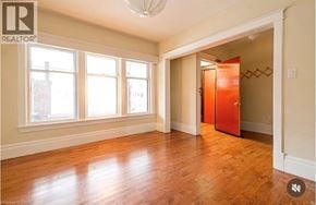 Hamilton apartment for rent - A room with wooden floors and a large window.