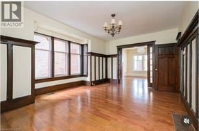 Hamilton apartment for rent - A large empty room with wood floors and a chandelier.