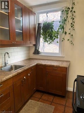 Hamilton apartment for rent - A kitchen with brown cabinets and a black dishwasher.